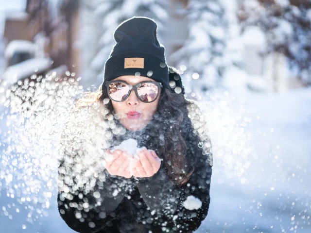 Girl blowing on the snow