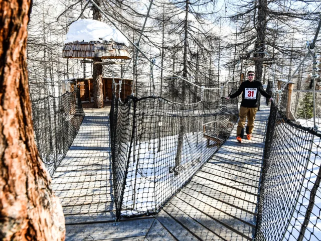 Un uomo felice sulle passerelle del Village Perdu in inverno in Val d'Isère