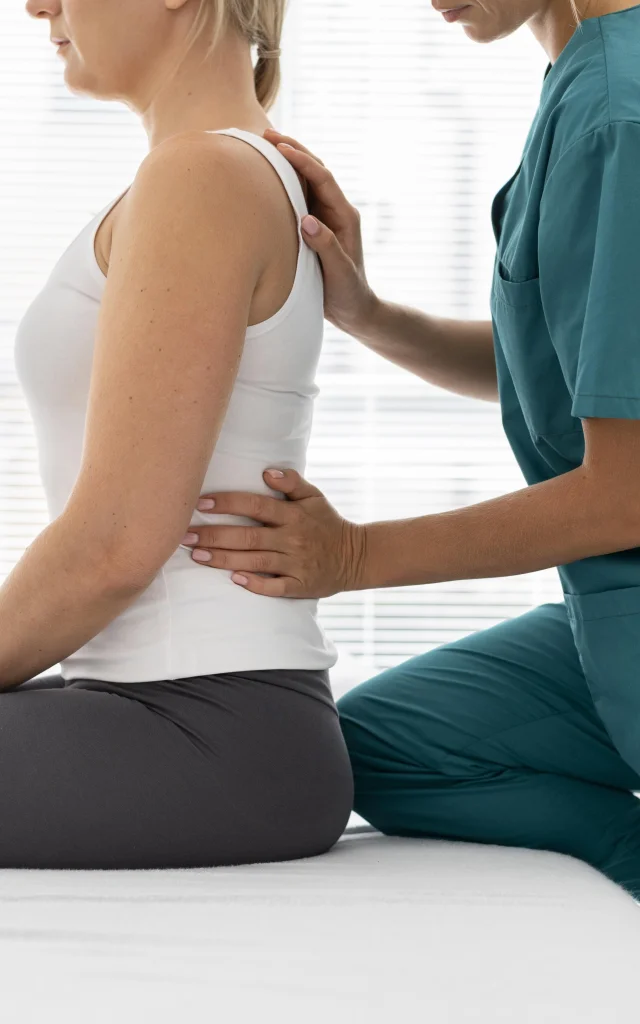 Young Physiotherapist Helping Patient with Back Problems
