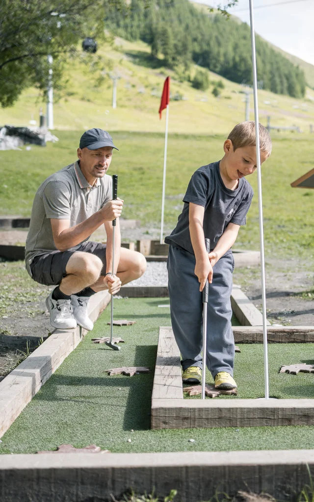 Family mini golf (parents and children) on the Val d'Isère green front in summer